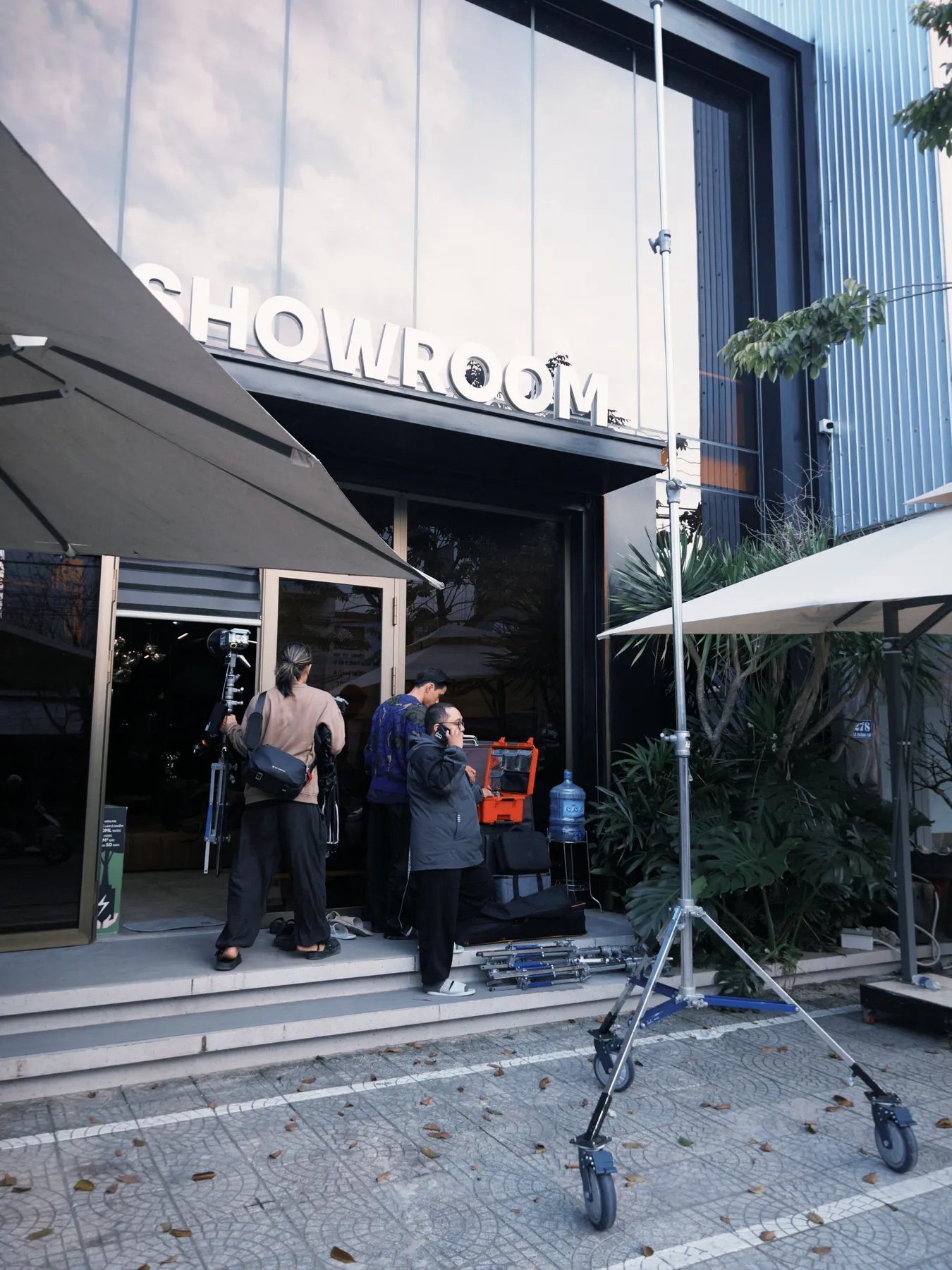 Ekip chuyển thiết bị trước cửa showroom trước giờ quay